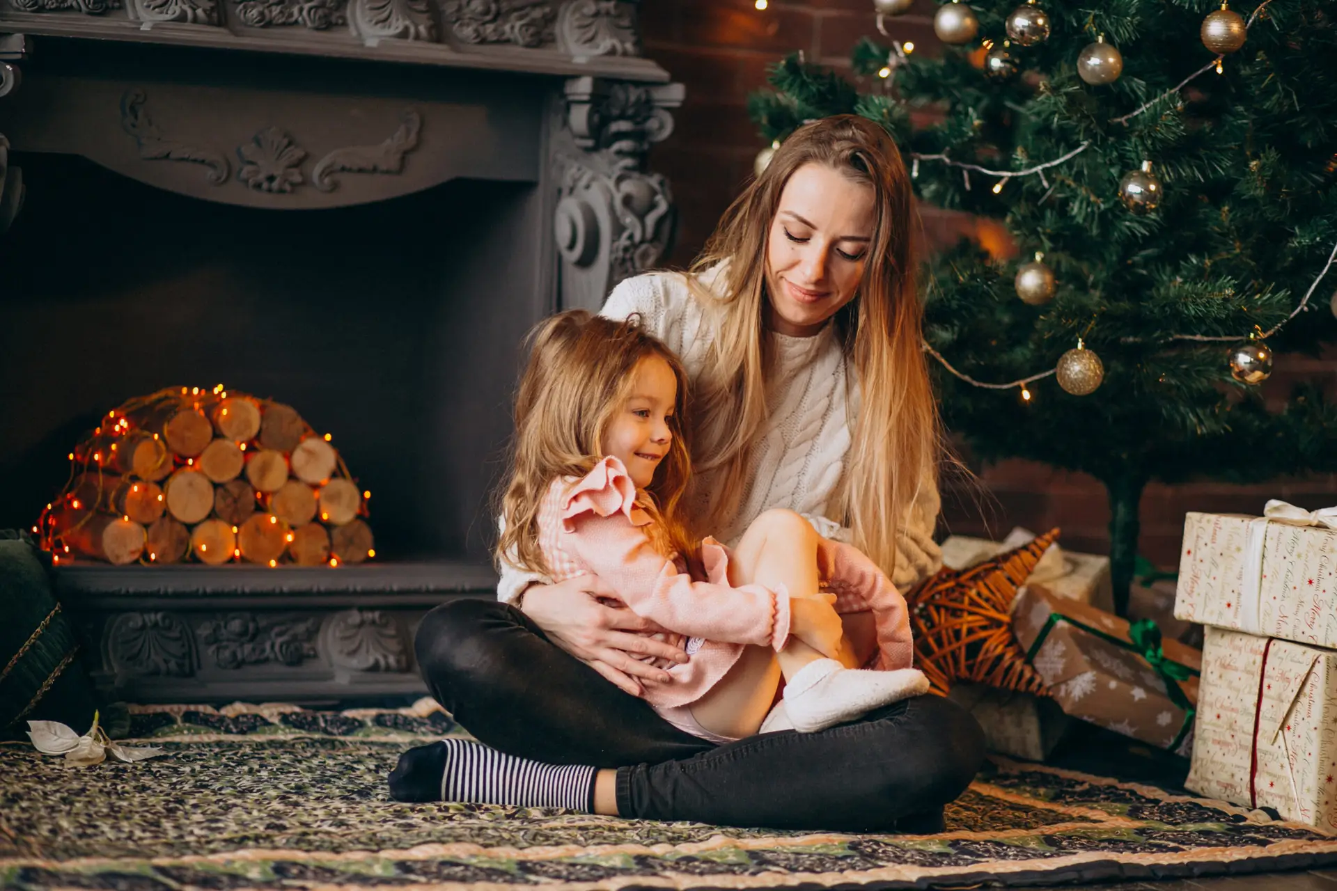 Madre con hija hablando frente al árbol de navidad